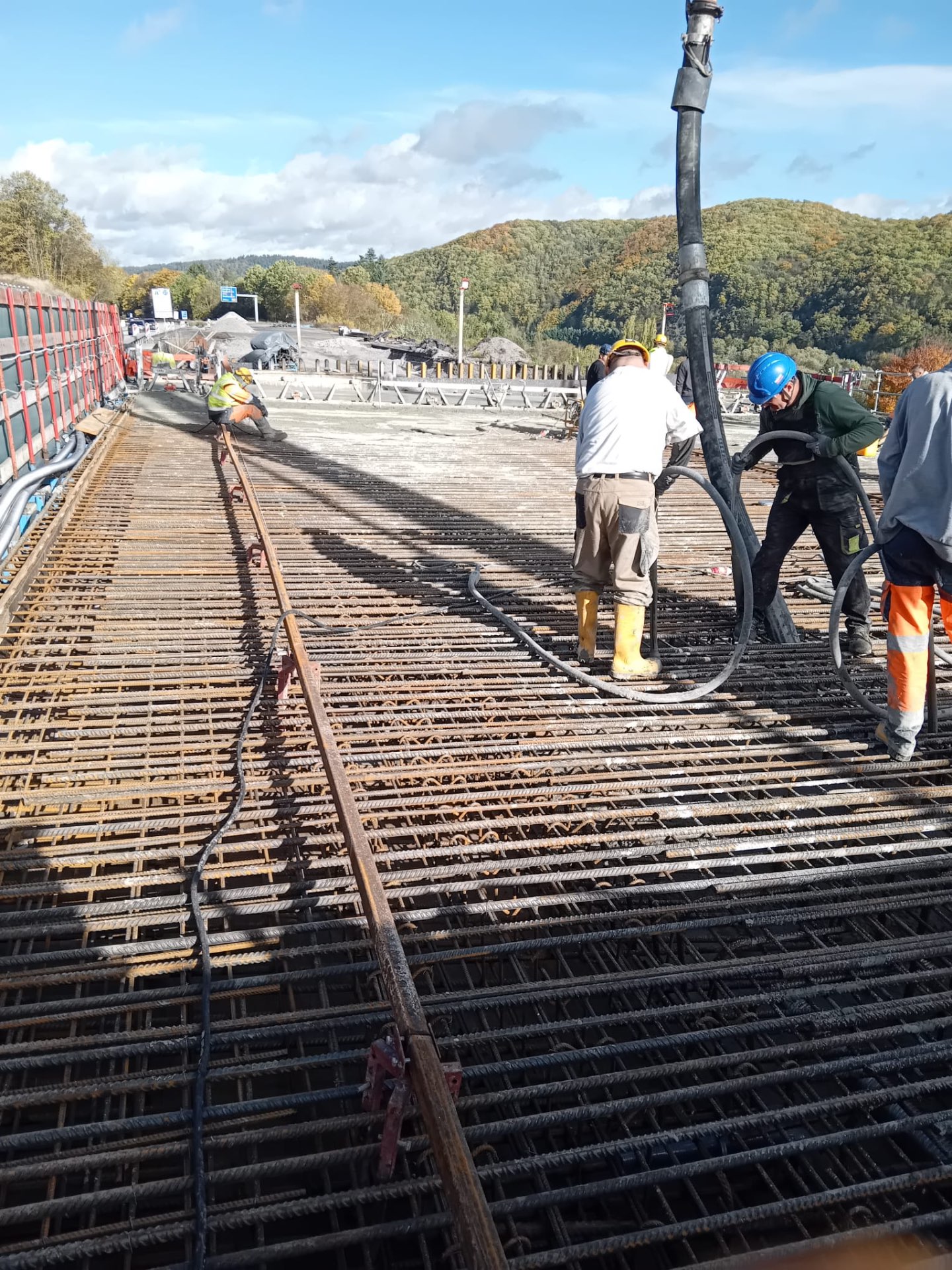 Betonage einer Brückendecke Bauarbeiter bei der Betonage einer Brückendecke mit Betonpumpe über fertig verlegter Bewehrung